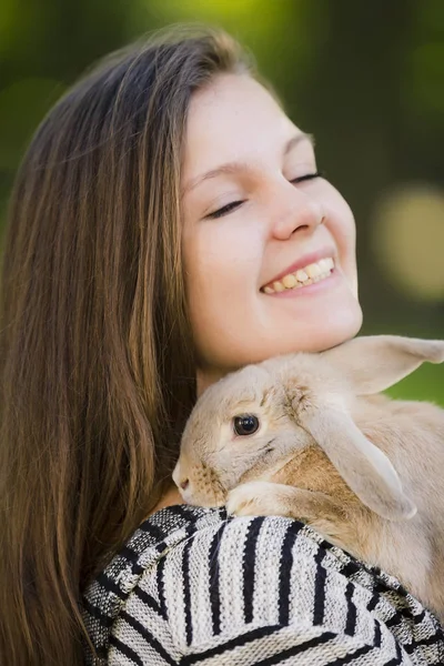 Menina feliz andando na primavera, parque de verão com seu coelho e sorrindo. Emoções de felicidade . — Fotografia de Stock