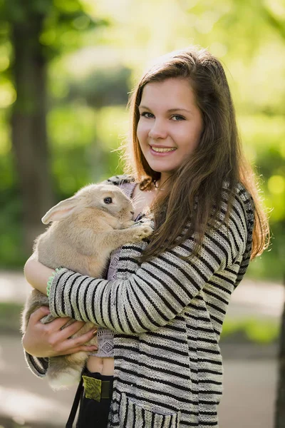 Menina feliz andando na primavera, parque de verão com seu coelho e sorrindo. Emoções de felicidade . — Fotografia de Stock