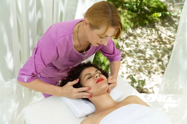 Bella donna bruna che fa un massaggio alla testa . Fotografia Stock
