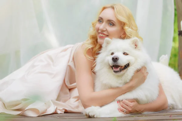 금발 여자는 손에서 하얀 강아지와 함께 야외에서 거짓말 — 스톡 사진