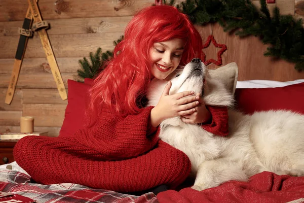 Σκύλος χειμερινές διακοπές και τα Χριστούγεννα. Ένα κορίτσι σε ένα πλεκτό πουλόβερ και με τα κόκκινα μαλλιά με ένα κατοικίδιο ζώο στο στούντιο. Χριστούγεννα γυναίκα με ένα όμορφο πρόσωπο και το κατοικίδιο ζώο σας. — Φωτογραφία Αρχείου