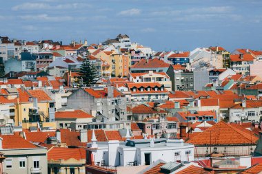 Arkasında dağ olan büyük turuncu bir bina. Lizbon 'un çatılarının manzarası. Portekiz