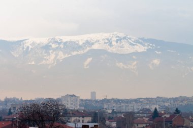 Fog over the city with Vitosha mountain in the background, illustrating high level of atmospheric particle pollution in winter clipart