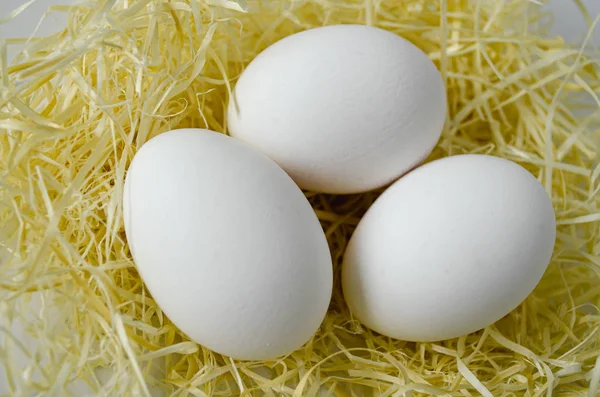 3 huevos sobre paja amarilla — Foto de Stock