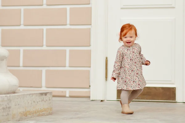 Fetiță cu părul roșu zâmbind și alergând în aer liber în toamnă — Fotografie, imagine de stoc