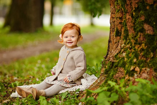 Roodharige meisje op de achtergrond van de natuur in een bos in — Stockfoto