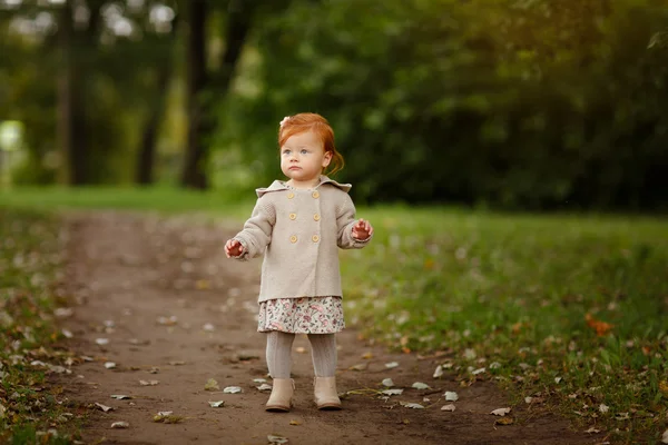Red-haired baby girl on the background of nature in a forest in — Stock Photo, Image