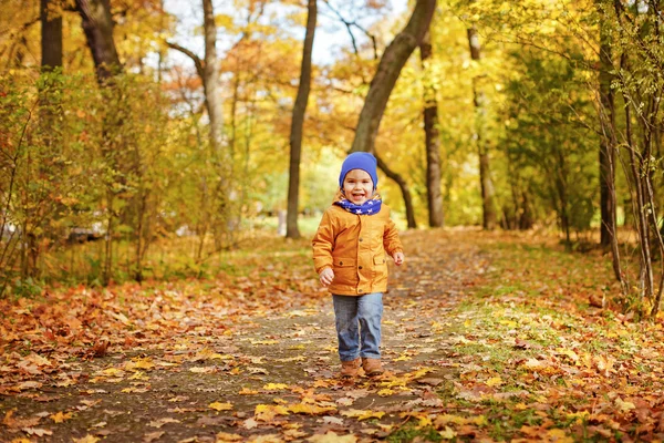 Schattig jongetje in gele jas langs het pad en — Stockfoto