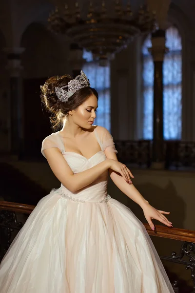 Beautiful brunette girl in white dress and with a brilliant crow — Stock fotografie