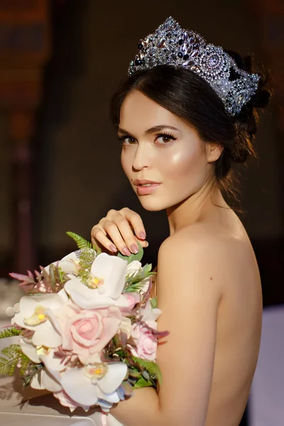 Beautiful brunette girl with a brilliant crown on her head and a — Stock fotografie