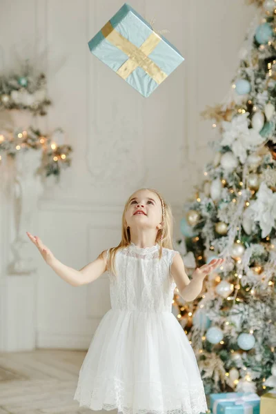 Krásná holčička, stojící poblíž vánoční strom a vrazila — Stock fotografie