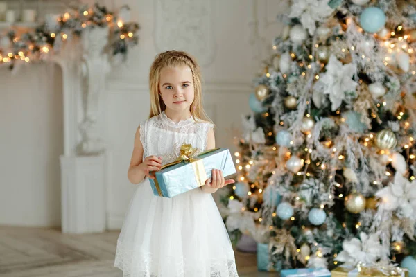 Belle petite fille debout près d'un arbre de Noël tenant un g — Photo