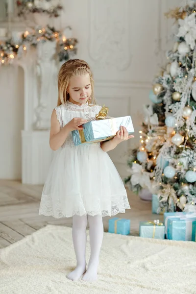 Krásná holčička, stojící poblíž vánoční stromek a hledá f — Stock fotografie