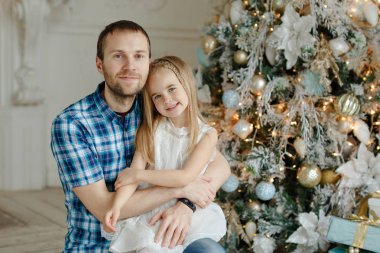 Christma arka plan üzerinde beyaz elbiseli kızı baba hugs