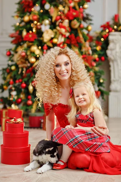 Кудрявая красивая молодая блондинка и дочь в красном платье — стоковое фото