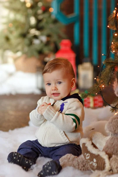 Băiatul cu obraji dolofan zâmbește de Crăciun. Interiorul — Fotografie, imagine de stoc