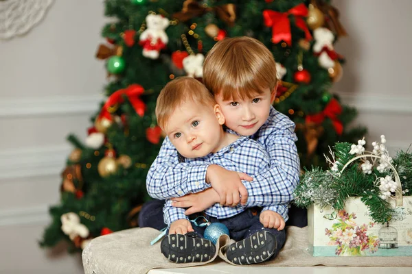 Dois irmãos de camisa azul sorrindo e abraçando no Natal — Fotografia de Stock