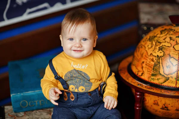 O menino com bochechas gordinhas sorrindo ao lado de um globo — Fotografia de Stock