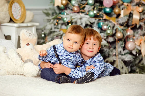 Dois irmãos de camisa azul sorrindo e abraçando no Natal — Fotografia de Stock