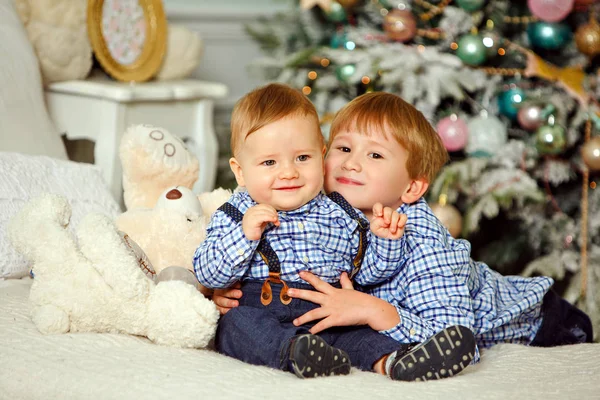 Dos hermanos con camisa azul sonriendo y abrazándose en Navidad — Foto de Stock