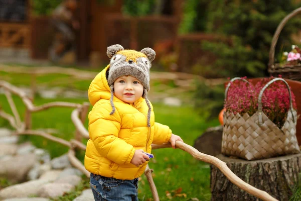 Baby jongetje in gele jas glimlacht in het najaar — Stockfoto