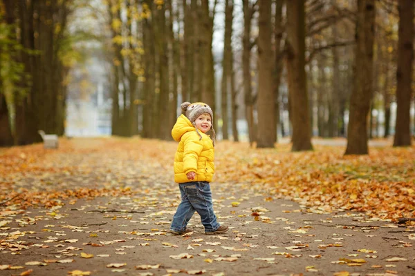 Baby jongetje in gele jas glimlacht in het najaar — Stockfoto