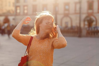 Kızıl saçlı kız etek yürür ve kafasını şehre dönüyor 