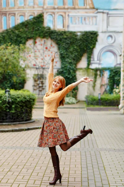 Рыжая девушка в юбке гуляет и радуется в городе на s — стоковое фото