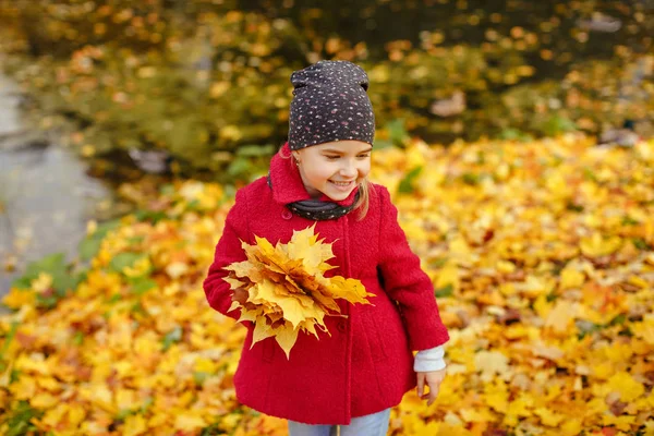 Маленька дівчинка в пальто восени в парку сміється щасливий — стокове фото