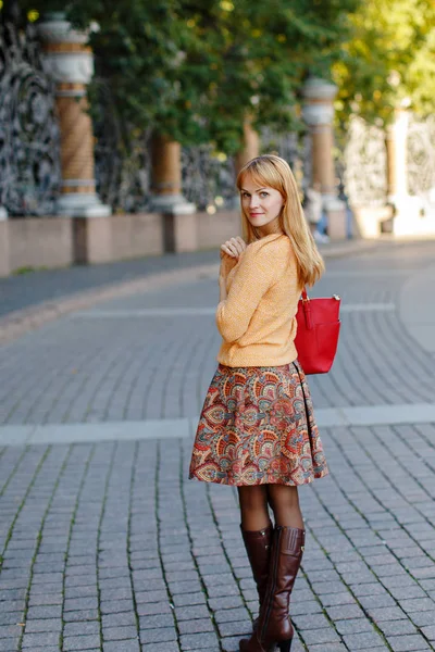 Chica pelirroja en una falda caminando en la ciudad en un día soleado — Foto de Stock