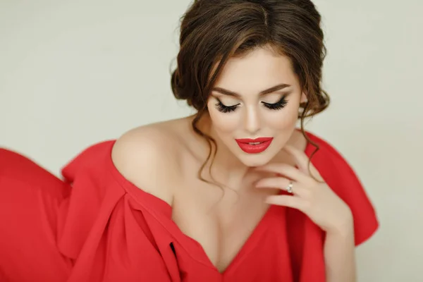 Элегантная сексуальная брюнетка в красном платье, смотрящая вниз — стоковое фото