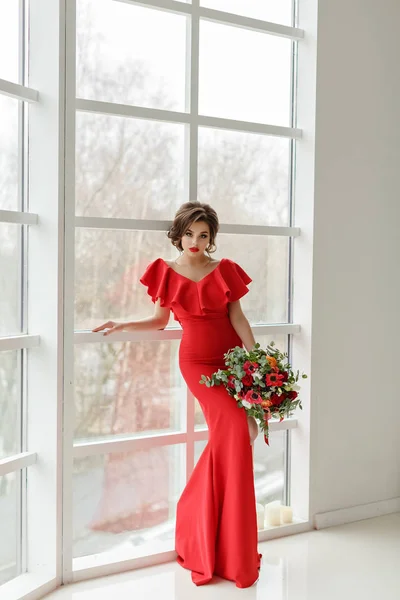 Elegant sexig brunett tjej i en röd klänning med en krans och en bo — Stockfoto