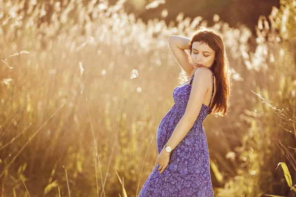 Mulher grávida macia bonita sorri e goza de um verão ensolarado — Fotografia de Stock