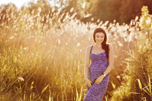 Mulher grávida macia bonita sorri e goza de um verão ensolarado — Fotografia de Stock