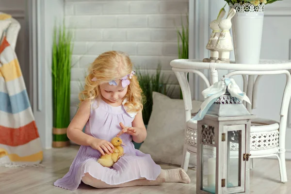 Чарівна маленька дівчинка блондинка в сукні тримає каченят, в — стокове фото