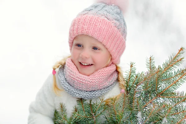 Little girl in a pink hat in winter smiles in the park — Stock Photo, Image