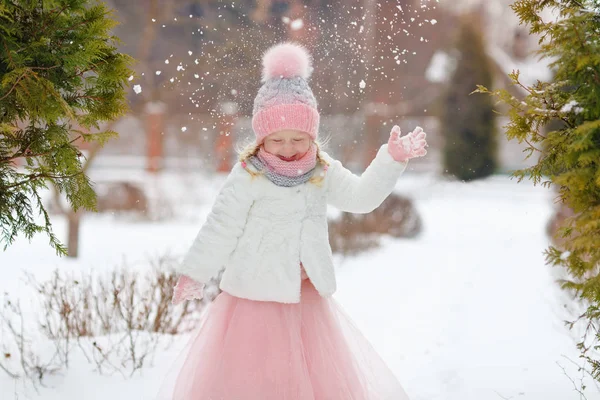 Bambina in gonna rosa in inverno sorride nel parco e thr — Foto Stock
