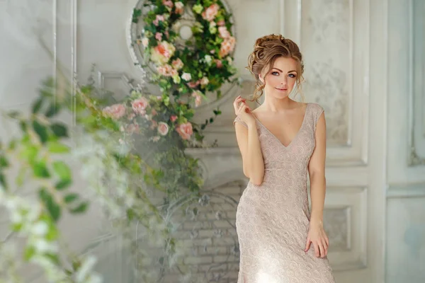 Hermosa chica sensual rubia en vestido beige sonríe suavemente en el — Foto de Stock