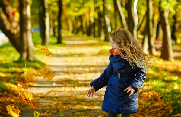 Красива 6-річна блондинка з довгим волоссям кидає листя — стокове фото