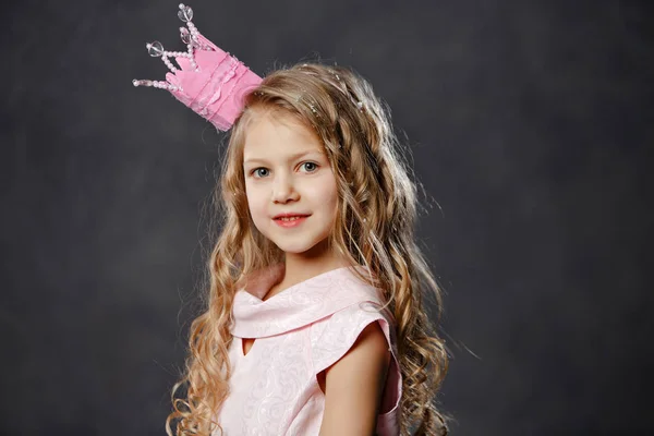 Retrato de una hermosa chica en una corona de princesa rosa en ba oscura —  Fotos de Stock