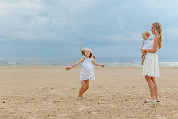 Mom the blonde and two daughters are played, jump and laugh at t — Stock Photo, Image