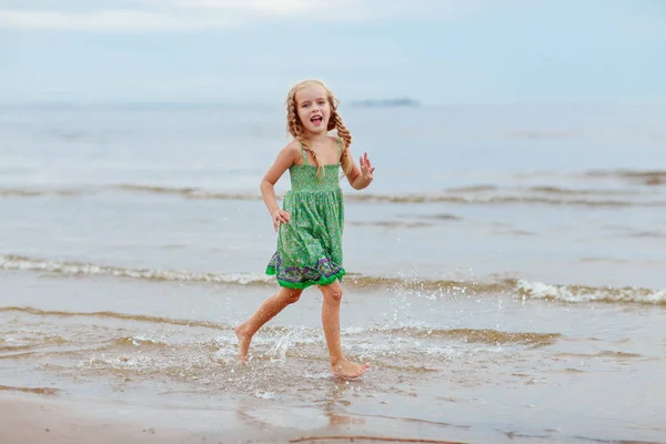 Petite fille blonde éjacule et rit au bord de la mer en été — Photo