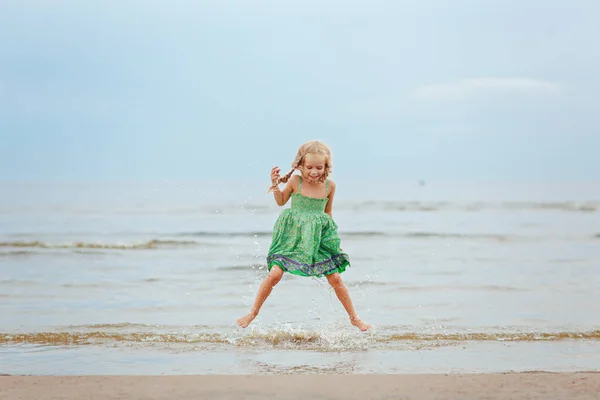 Petite fille blonde éjacule et rit au bord de la mer en été — Photo
