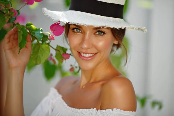 Bronceada hermosa y sexy chica en un sombrero blanco sonríe, en la suma — Foto de Stock