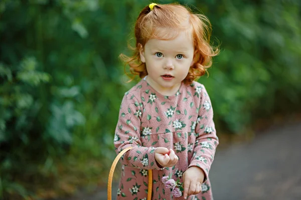 Little beautiful red-haired little girl looks seriously, summer — Stock Photo, Image