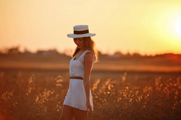 Πανέμορφο λεπτό κορίτσι σε λευκό φόρεμα και καπέλο είναι το περπάτημα στο το — Φωτογραφία Αρχείου