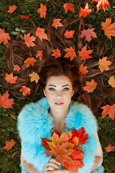 Very beautiful young brunette woman lies on the grass, her orang — Stock Photo, Image