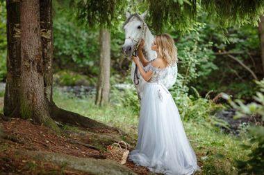 Gri bir atı outd sarılma elbiseli güzel ince sarışın kız