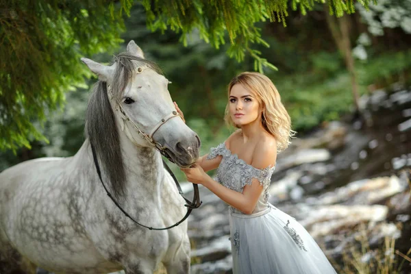 Gri bir atı outd sarılma elbiseli güzel ince sarışın kız