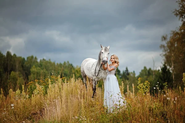 Gri bir at dışarı sarılma elbiseli güzel ince sarışın kız